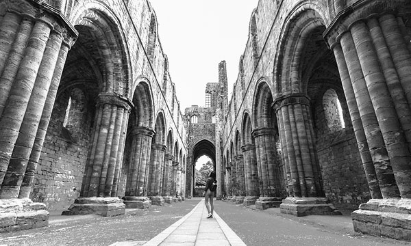 tourist
                  viewing Leeds Abbey ruins